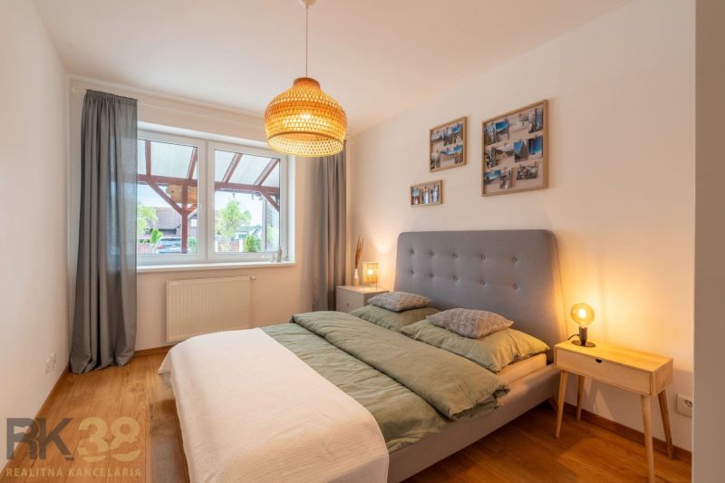 A bedroom with a gray headboard and a wooden decor floor in a two-room apartment.