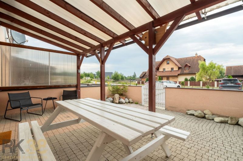 A terrace with a table at a 2-room apartment in Poprad, with a covered seating area.