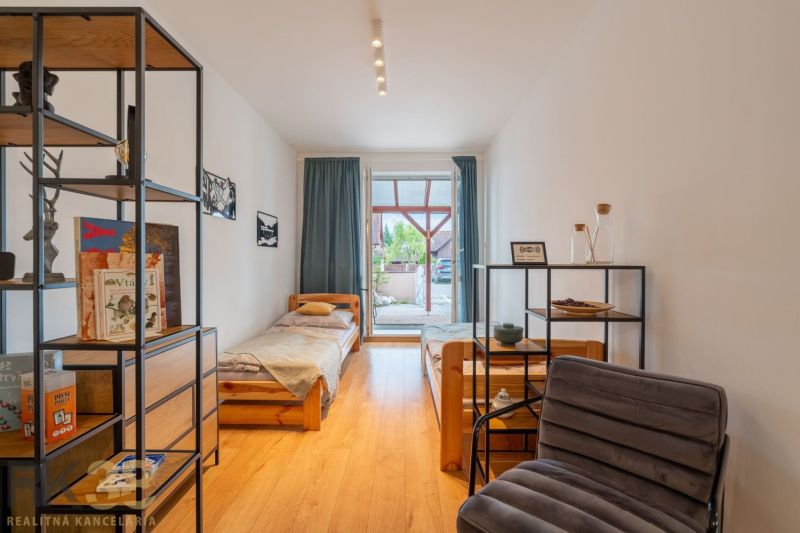 A children's room with beds and a wooden decor floor in a 2-room apartment.
