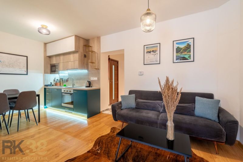 Living room in a two-room apartment with a kitchen and a wooden decor floor.