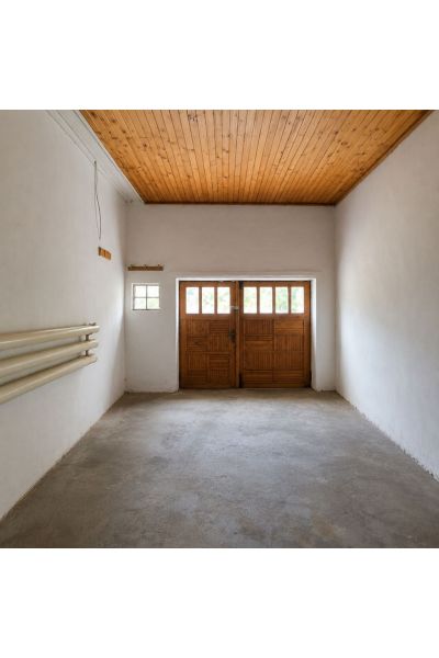 Empty garage in a family house with a wooden ceiling and large doors.