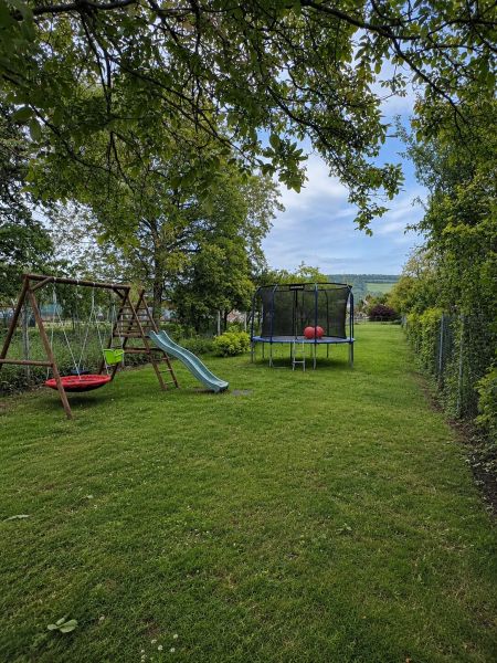 The garden of a family house on Gardom Street in the town of Veľký Šariš with a swing and a trampoline.