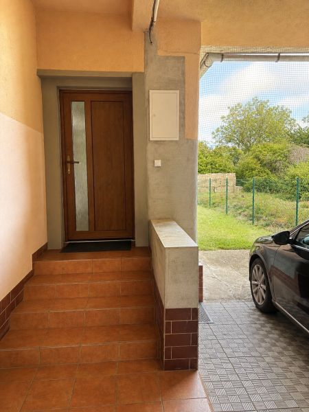 The entrance staircase of a family house on Gardom Street in Veľký Šariš, with a parked car next to it.