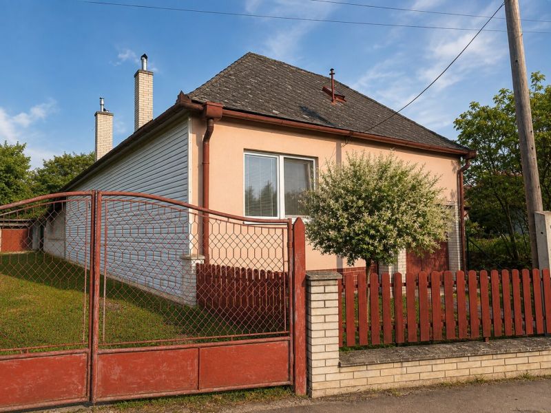 A family house on Gardom Street, Veľký Šariš, with a red fence and a lawn.