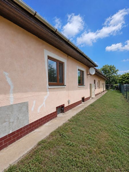 The side facade of a family house on Gardom Street in Veľký Šariš with a manicured lawn.