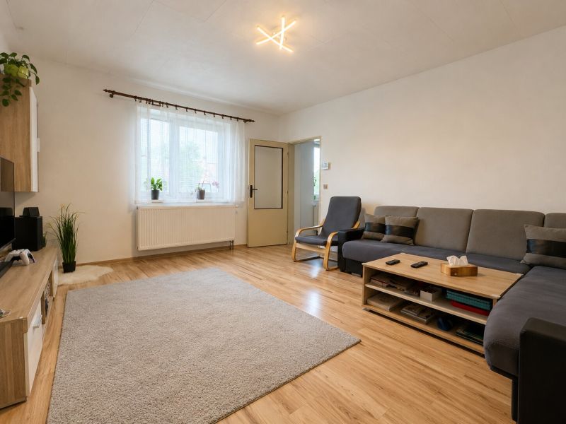 Living room in a family house with a wood-patterned floor and comfortable seating.