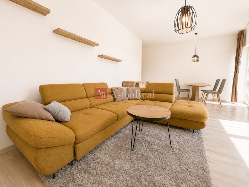 Living room in a 3-room apartment with a comfortable mustard sofa and decorative shelves.