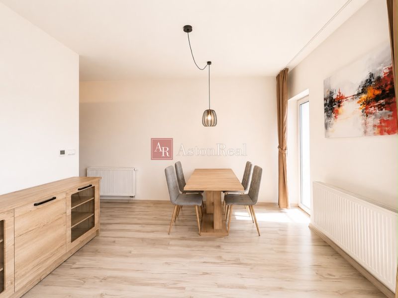 Dining room in a 3-room apartment with a wooden decor floor and simple furniture.