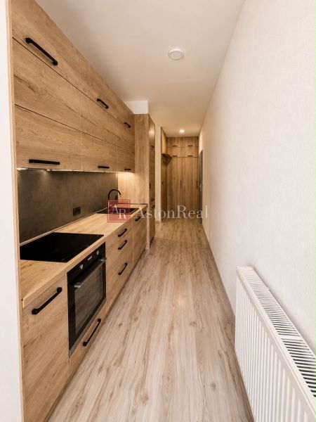A narrow kitchen in a 3-room apartment with wooden decor and a radiator.