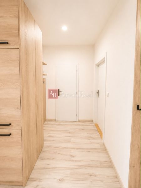 Cozy hallway in a 3-room apartment with a wooden decor floor.