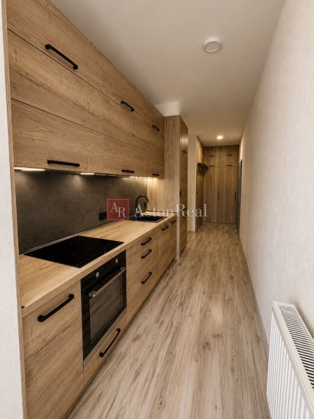A kitchen with a wooden decor floor and furniture in a 3-room apartment.