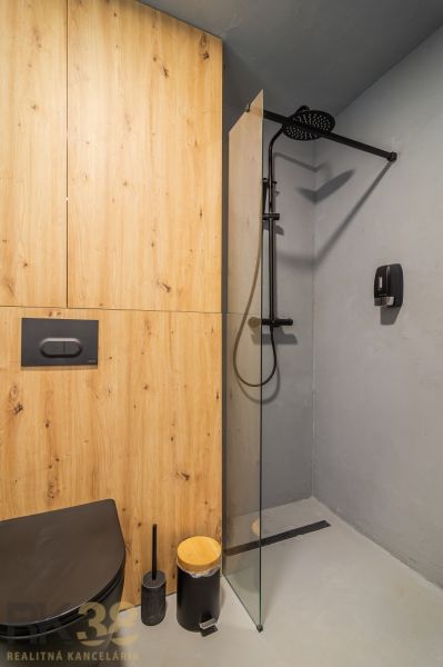 Bathroom in a holiday apartment with wood-effect flooring and a shower enclosure.