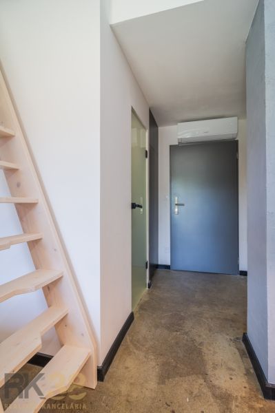 Hallway of a recreational apartment with wooden stairs and doors.