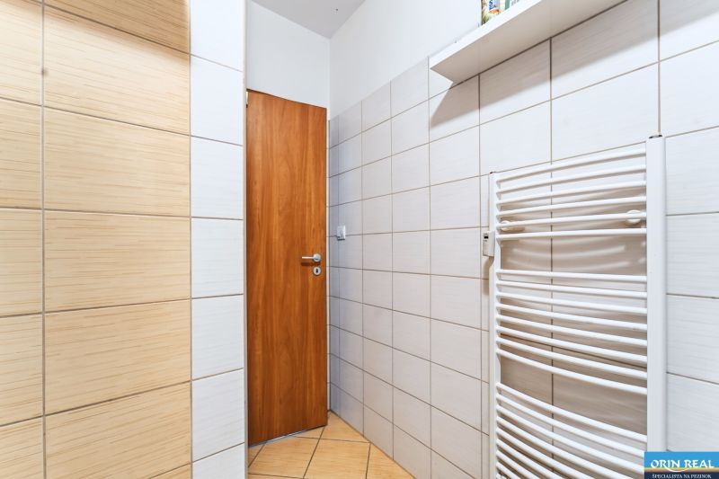 A bathroom with tiles and a white radiator in a 3-room apartment.