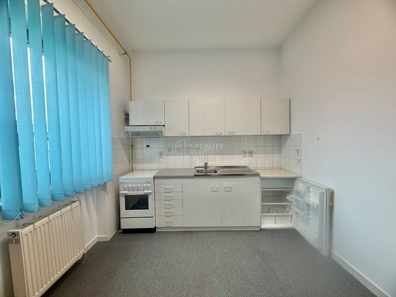 Kitchen area in Offices with white cabinets and blue blinds.
