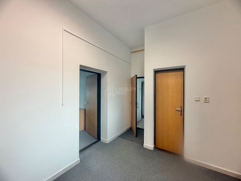 Interior with two wooden doors and light-colored walls in an office.