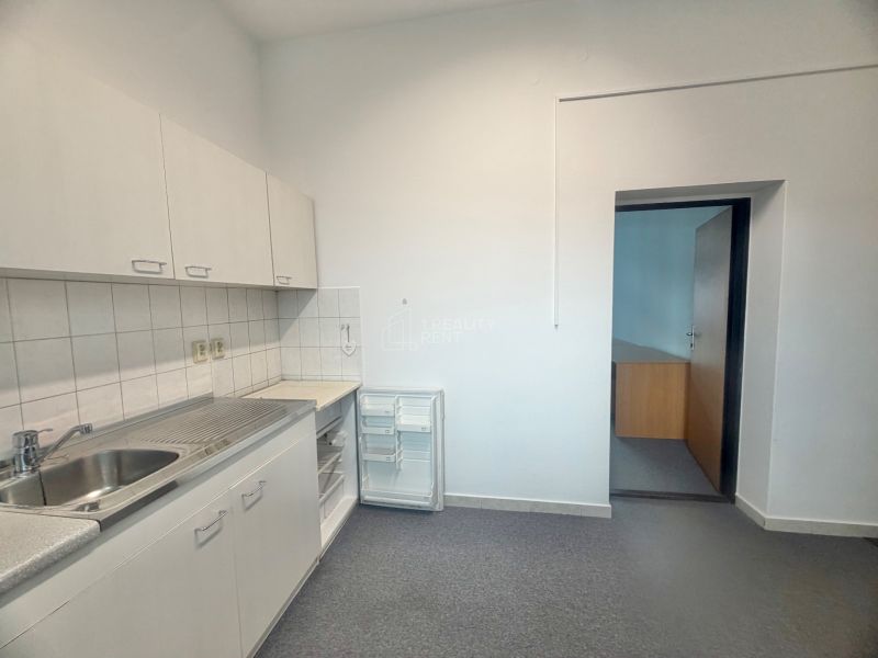 Offices with a built-in kitchenette, bright walls, compact storage spaces, practical solution.