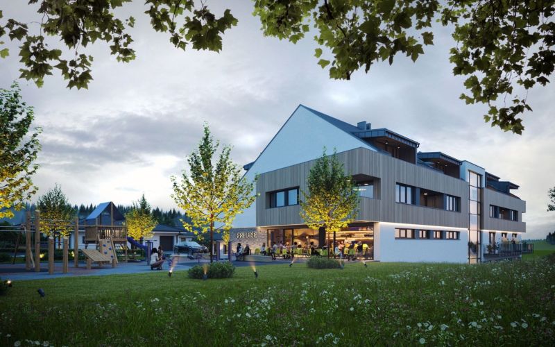 A building surrounded by trees and a playground in Mlynica, at sunset.