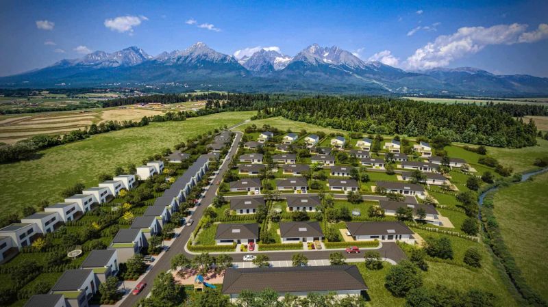 Aerial view of new residential buildings in Mlynica with a mountain backdrop.