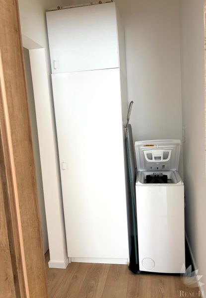 Bathroom with a washing machine in a 3-room apartment and a floor with a wood decor.