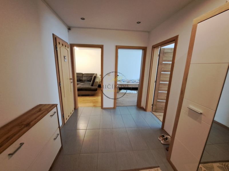 A hallway of a 3-room apartment with a wooden decor floor and a view into the rooms.