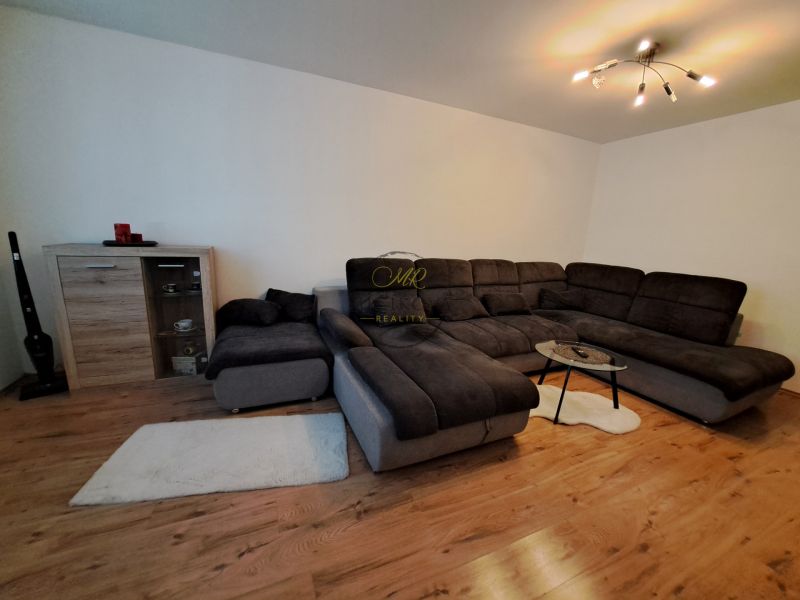 Living room in a three-room apartment with a sofa and a wooden decor floor.