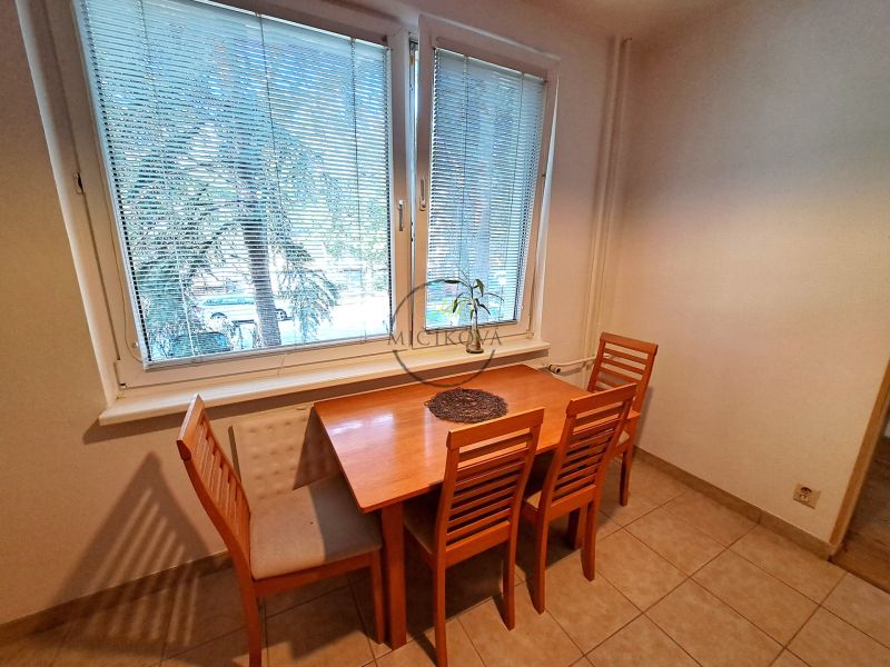 A dining table with four chairs in the kitchen of a three-room apartment.
