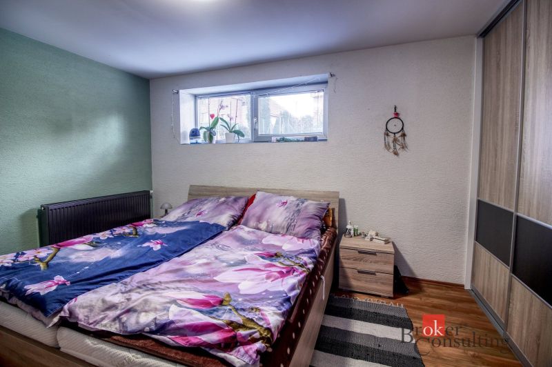 Bedroom in a family house with decorative flooring, bed, and wardrobe.
