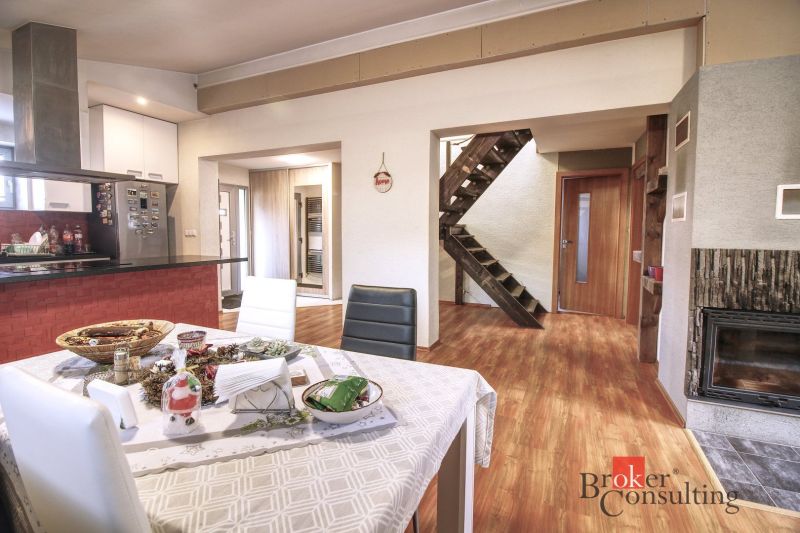 Interior of a family house with a dining room, fireplace, and floor with wooden decor.