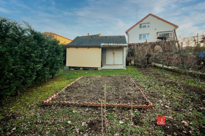 A garden at a family house in Suchá nad Parnou with a lawn and a small storage.