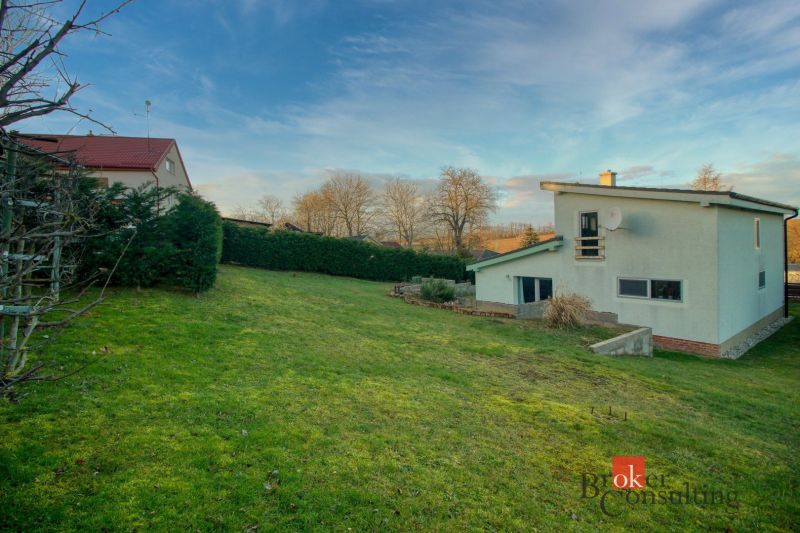 A family house in Suchá nad Parnou surrounded by a green lawn and a hedge.