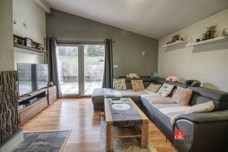 Living room in a family house with a corner sofa and a wooden decor floor.