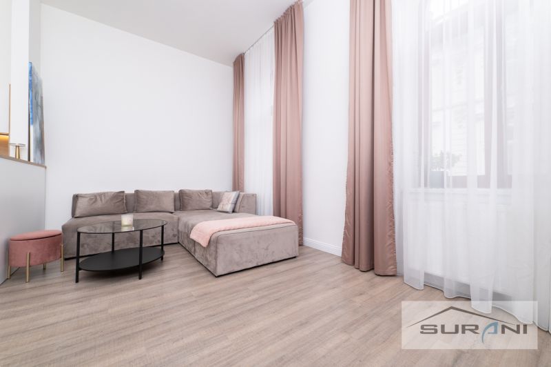 Living room with a corner sofa, coffee table, and wooden decor flooring.