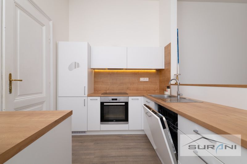 A kitchen in a 2-room apartment with a light decor and wooden elements.