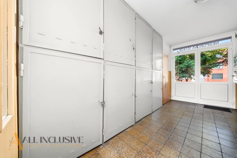 A hallway with security lockers and tiles in a 2-room apartment.