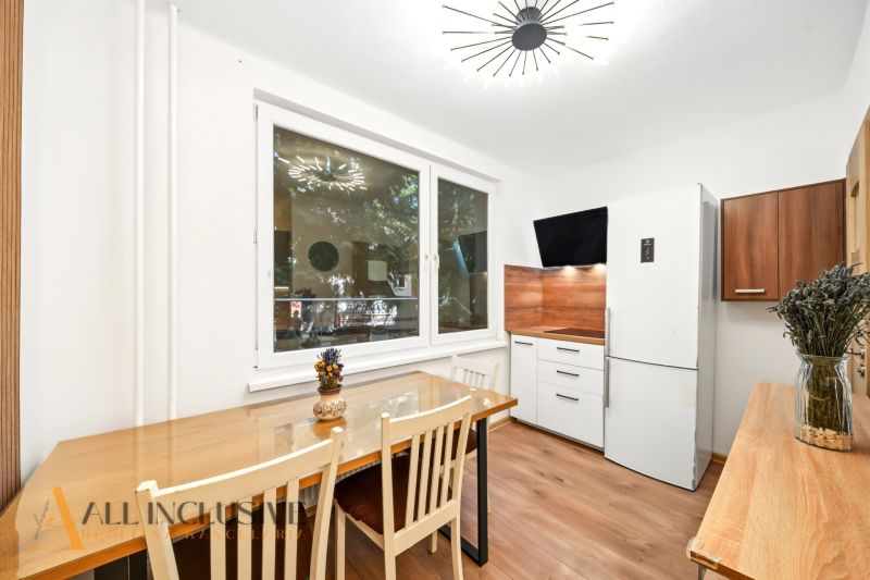 A kitchen in a 2-room apartment with a wooden decor floor and modern lighting.