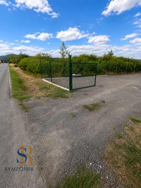 Lands - housing in Modra on street 504, fenced area, greenery, asphalt road.