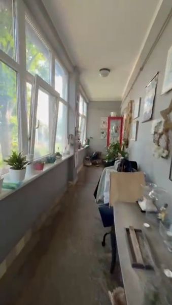 A glazed veranda in a family house with plants and decorations.