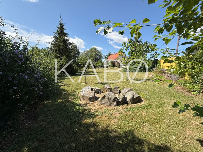 The garden of a family house in Čaradice surrounded by greenery and trees.