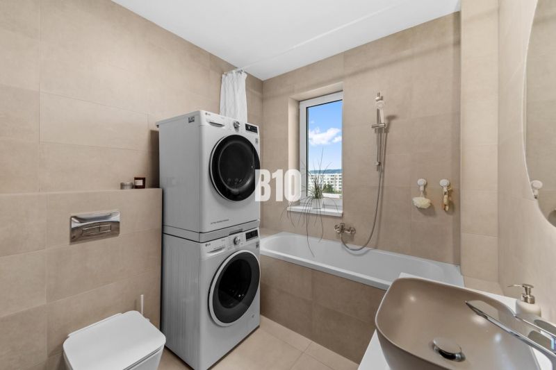 Bathroom with shower, washing machine, and dryer in a 4-room apartment, simple design.