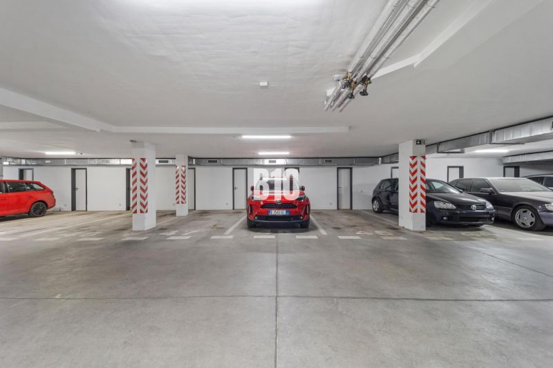 Underground garage with parked cars in a 4-room apartment in Nitra, concrete floor.