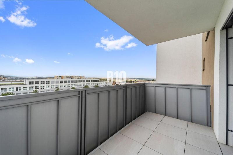 The balcony of a 4-room apartment in Nitra with a view of modern buildings.
