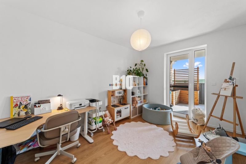 Children's room in a four-room apartment with a wooden decor floor and a play corner.