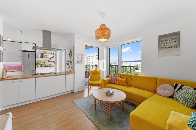 Living room of a 4-room apartment with a wooden decor floor and a yellow sofa.