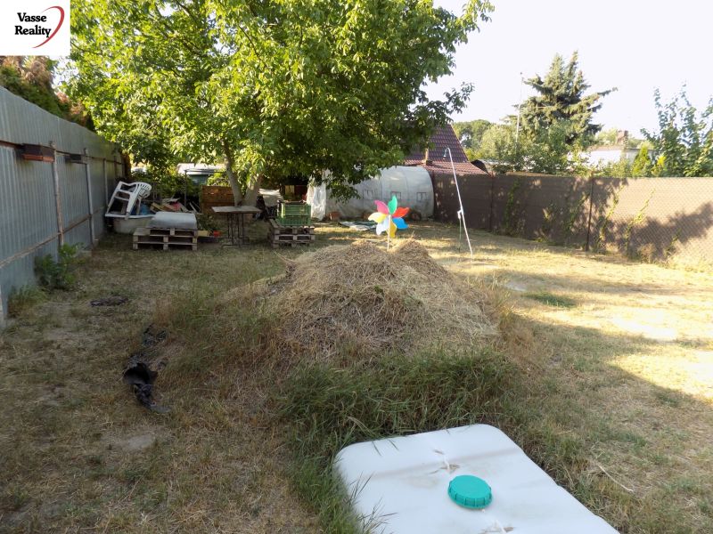 The garden by the Cottage on the Pumpkin Field in Nové Zámky with a pile of hay and a tree.