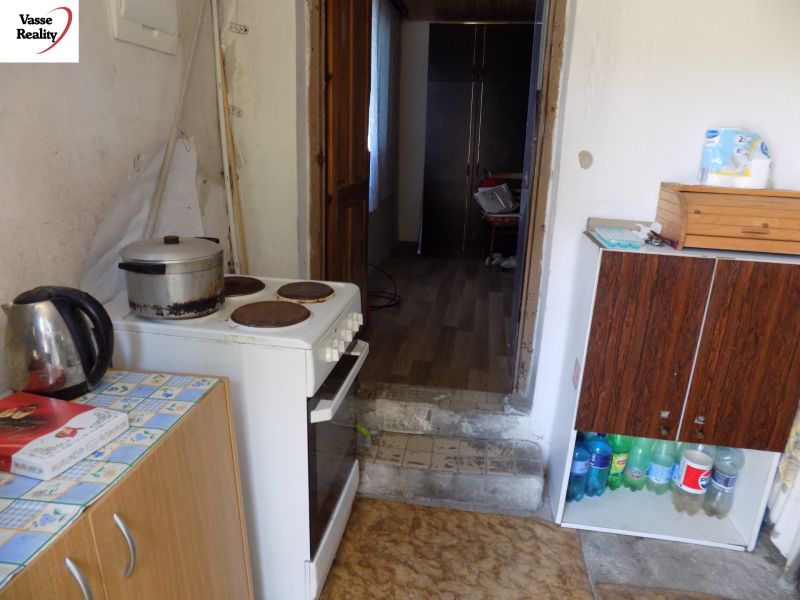 Cottage kitchen with a mix of furniture, electric stove, and wooden decor flooring.