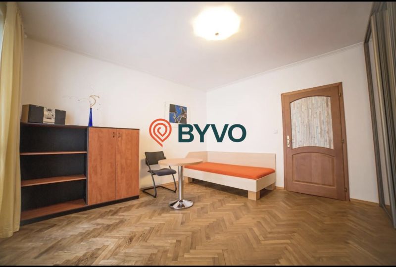 A room with a wooden floor decor in a 3-room apartment, with furniture and decoration.
