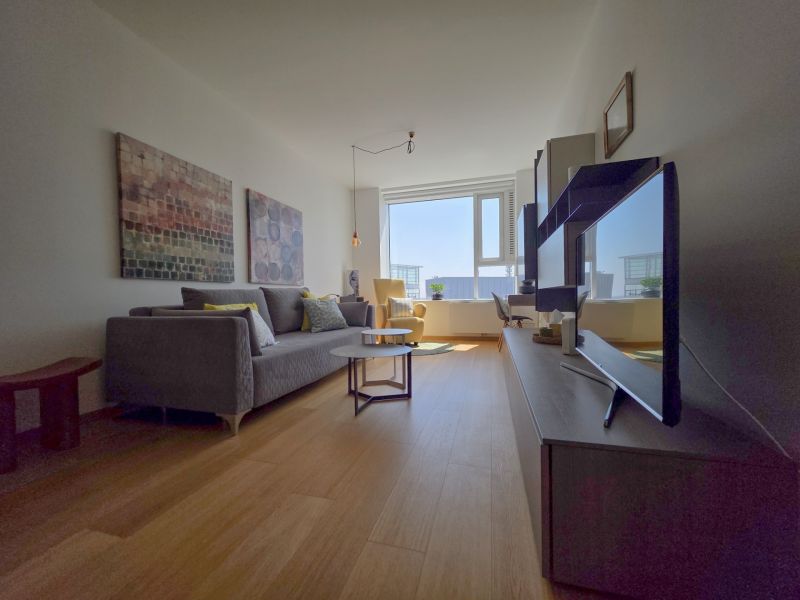 Living room in a studio apartment with a wooden floor design and a sofa.