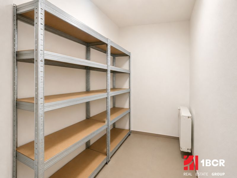 Storage space in a 4-room apartment with metal shelves and a radiator.