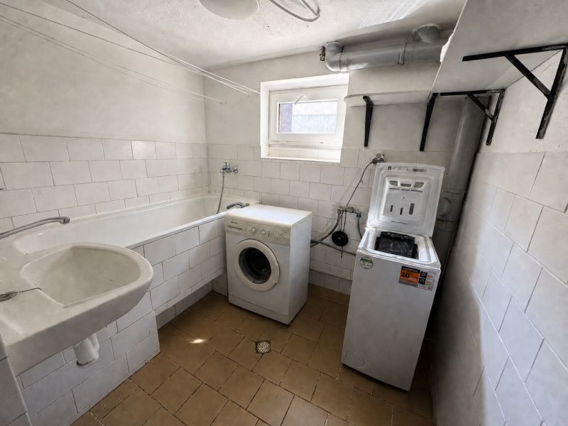 Bathroom in a family house with a bathtub and washing machines.